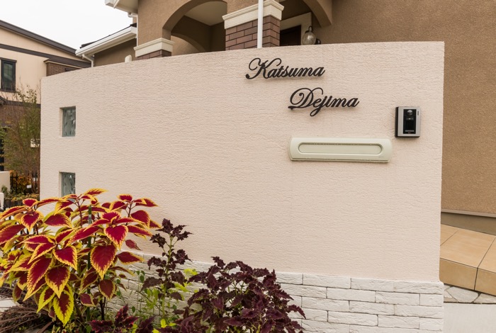 アール状に曲げてデザインした壁は、玄関ドアの奥に向かう視線をさり気なくカットしてくれます。美しい風合いをいつまでも楽しめるよう、壁の下の部分にはレンガを貼っています。これは、雨の際に泥水がはねても壁に付着しないようにするためです。汚れ防止にも役立ち、さらにデザイン性も向上しましたね。