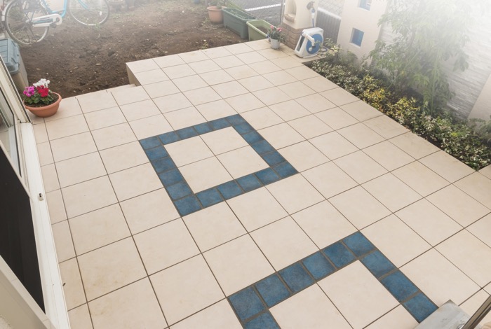 メインガーデンの面積をしっかり使って造作したタイルテラスは2種類のタイルで造作しました。メインとなるタイルは玄関前にも使った薄いベージュタイプで、テラスの中心には鮮やかな青のタイルを組み合わせています。